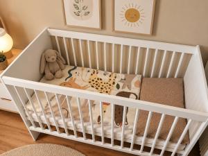 a white crib with a teddy bear in a room at Spanisches Haus in Staßfurt