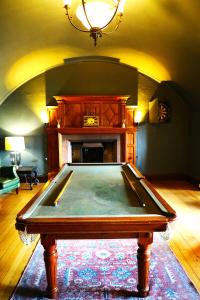 a pool table in a room with a fireplace at Dalston Hall in Carlisle