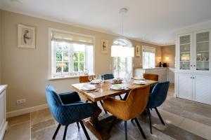 a dining room with a wooden table and blue chairs at Litzkow 11205 in Morsum