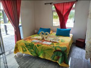 a bedroom with a bed with a tropicalspread and a window at Terai vahine lodge in Rangiroa
