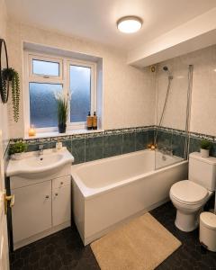 a bathroom with a tub and a toilet and a sink at Veronika Double Room in London