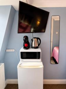 a microwave with a tea kettle on top of it at Veronika Double Room in London