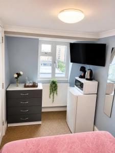 a kitchen with a refrigerator and a microwave at Veronika Double Room in London