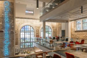 a lobby with tables and chairs and a brick wall at Hotel Oderberger in Berlin