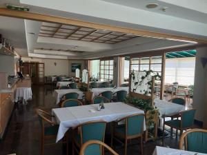 ein Esszimmer mit Tischen, Stühlen und Fenstern in der Unterkunft Hotel Orijent 22 in Laktaši