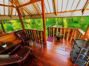 a porch with chairs and a wooden floor at Nethmini Leege Cottage in Kibissa