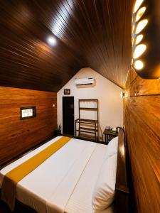a large bed in a room with a wooden ceiling at Nethmini Leege Cottage in Kibissa +8 photos