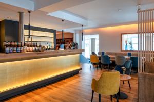 a bar in a restaurant with chairs and a counter at Hotel Selliner Hof in Ostseebad Sellin