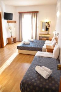 a hotel room with two beds and a mirror at Hotel Filoxenia Beach in Leptokarya