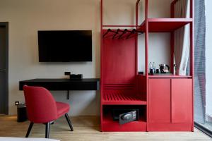 a red cabinet with a desk and a red chair at Lantern Chiang Mai Night Bazaar Hotel in Chiang Mai