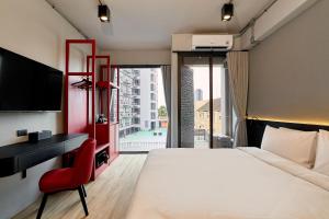 a bedroom with a bed and a desk and a tv at Lantern Chiang Mai Night Bazaar Hotel in Chiang Mai +76 photos