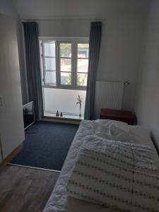 a bedroom with a bed and a large window at Tversted Strandkro in Bindslev