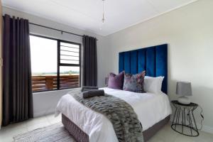 a bedroom with a large bed and a large window at #AlimamaSpaces Pano's Greenpark in Boksburg +53 photos