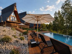 a patio with an umbrella and chairs next to a pool at Dilok Hills in Mykulychyn
