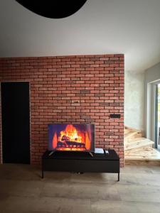 a living room with a fireplace in a brick wall at Black House in Sława