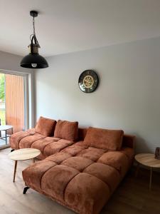 a living room with a couch and a clock on the wall at Black House in Sława