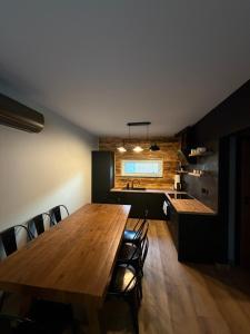 a kitchen and dining room with a wooden table and chairs at Black House in Sława