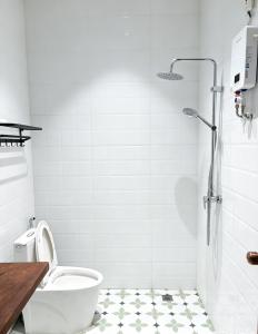 a white bathroom with a toilet and a shower at Tea time B&B 叙茶时光客栈 in Luang Prabang