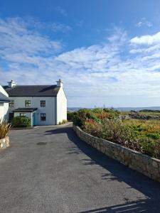 a white house with the ocean in the background at The Point by the Sea in Carraroe