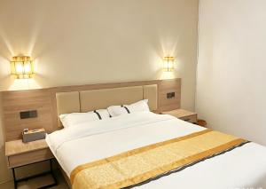 a bedroom with a large white bed and two lights at Tea time B&B 叙茶时光客栈 in Luang Prabang