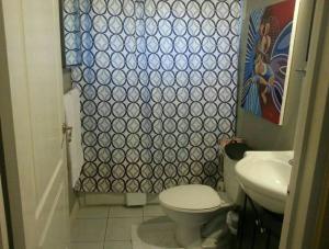 a small bathroom with a toilet and a sink at Caribbean Estate AJ in Portmore +9 photos