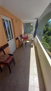 a room with a balcony with chairs and a couch at Nikola CG in Sutomore