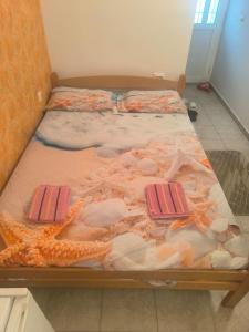 a large bed with shells on it in a room at Nikola CG in Sutomore