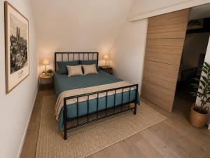 a bedroom with a bed and a sliding door at Logis de l'Éperon Laon in Laon