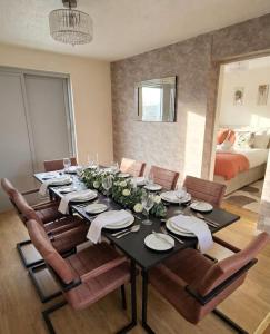 a dining room with a table and chairs and a bed at Modern Large 5-Bed-2 Baths-Parking-Great for Groups-Contractors-Families-Royal Leamington Spa-Warwickshire-By The Home Makers Hub in Leamington Spa +18 photos