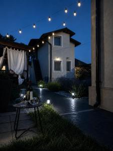 a patio with a table with wine glasses on it at night at Casa 1A in Eforie Sud