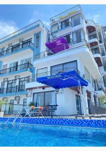 a building with an umbrella next to a swimming pool at Gấu Home Tây's in Tam Ðảo