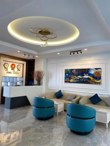 a living room with a couch and blue chairs at Gấu Home Tây's in Tam Ðảo