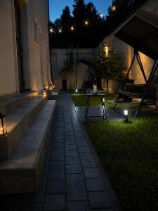 a patio with a table in the grass at night at Casa 1A in Eforie Sud