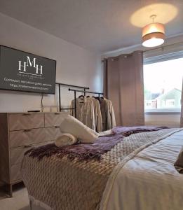a room with a bed and a tv and clothes at Modern Large 5-Bed-2 Baths-Parking-Great for Groups-Contractors-Families-Royal Leamington Spa-Warwickshire-By The Home Makers Hub in Leamington Spa