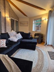 a living room with a black couch and a rug at Modern Large 5-Bed-2 Baths-Parking-Great for Groups-Contractors-Families-Royal Leamington Spa-Warwickshire-By The Home Makers Hub in Leamington Spa