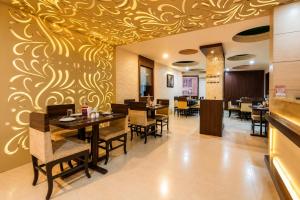 a restaurant with a dining room with tables and chairs at Ashish Palace - A City Centre Hotel in Udaipur