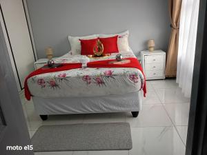 a bedroom with a bed with a red and white comforter at Green Harvest BnB in Newmansford