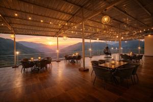 a restaurant with tables and chairs and a view of mountains at The Four Season Resort, Mussoorie - top rated & most awarded property in mussoorie in Mussoorie +29 photos