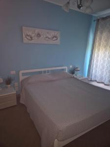 a blue bedroom with a bed and a window at Le Dune per 4 - Appartamento con piscina in Silvi Paese