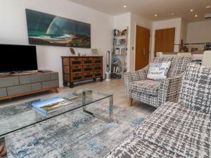 a living room with two chairs and a tv at The Trick in St Ives