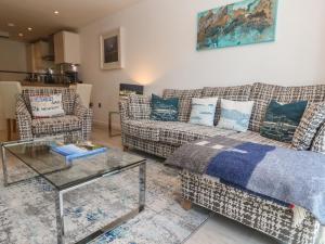 a living room with two couches and a glass table at The Trick in St Ives