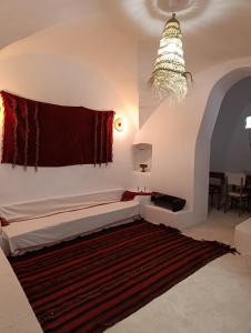 a living room with a bed and a chandelier at Dar Toubib in Qaşr Chouline +38 photos