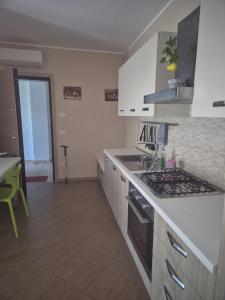 a kitchen with a sink and a stove top oven at Le Dune per 4 - Appartamento con piscina in Silvi Paese