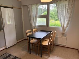 a dining room with a table and chairs and a window at Ravikatu, Oulainen, in Oulainen