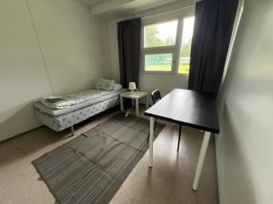 a room with a bed and a table and a window at Ravikatu, Oulainen, in Oulainen