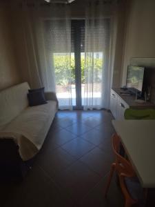 a living room with a couch and a desk with a computer at Le Dune per 4 - Appartamento con piscina in Silvi Paese