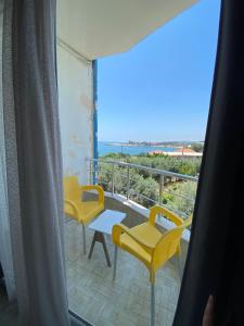 a room with a balcony with yellow chairs and a table at Atlas Butik Otel in Kizkalesi