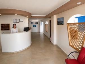 a woman standing at a counter in a hospital lobby at Atlas Butik Otel in Kizkalesi
