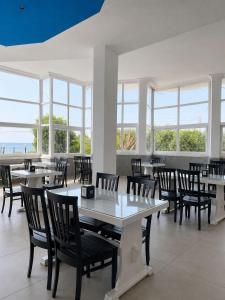 a dining room with tables and chairs and windows at Atlas Butik Otel in Kizkalesi