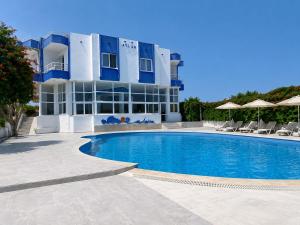 a swimming pool in front of a building at Atlas Butik Otel in Kizkalesi